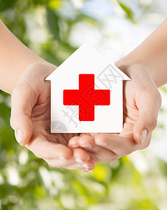 医疗保健医药慈善理念双手着带红十字标志的白纸屋图片