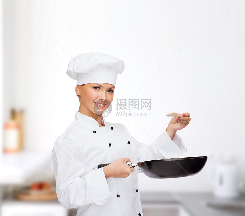 烹饪食物微笑的女厨师,厨师包师与锅勺子品尝食物图片