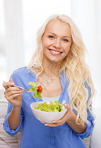 健康,节食,家庭幸福的微笑的轻女人与绿色沙拉家里图片