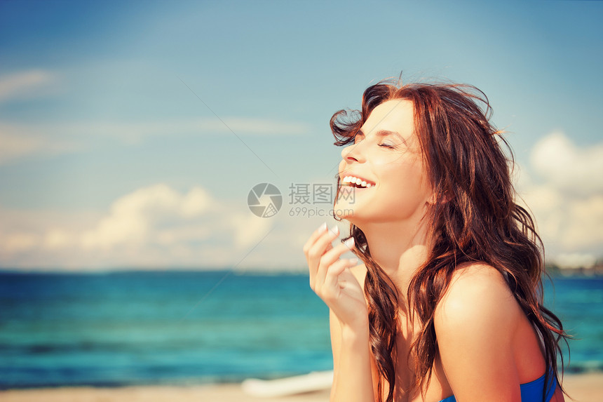 海滩上笑女人的明亮照片图片