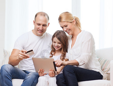 家庭wifi家庭,孩子,技术,金钱家庭微笑的父母小女孩与平板电脑信用卡家里背景