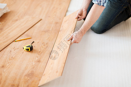 层压材料修理,建筑家庭男的手插入木地板背景
