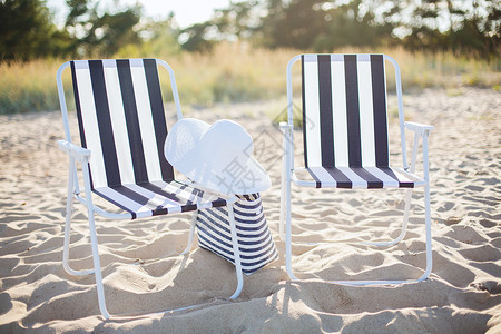 家具暑假两个海滩休息室与海滩袋白色帽子海滩上图片