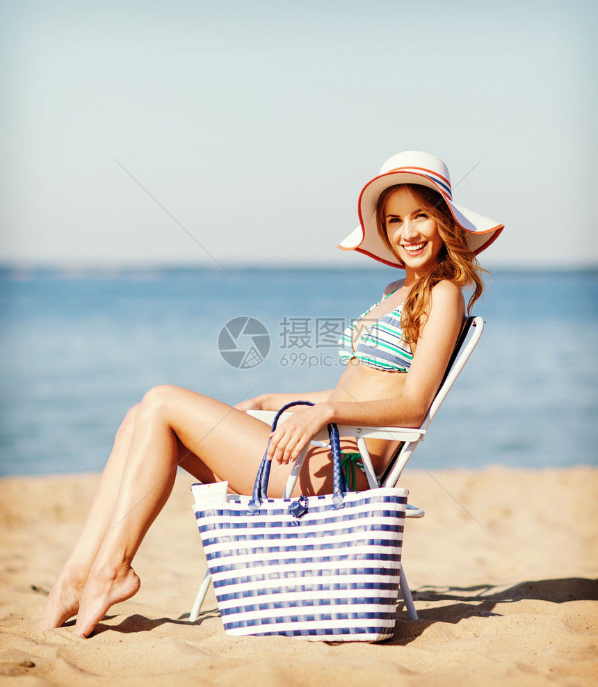 暑假假期女孩穿着比基尼海滩椅子上晒太阳图片