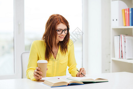 教育理念微笑的学生女孩戴眼镜读书,图书馆笔记背景图片
