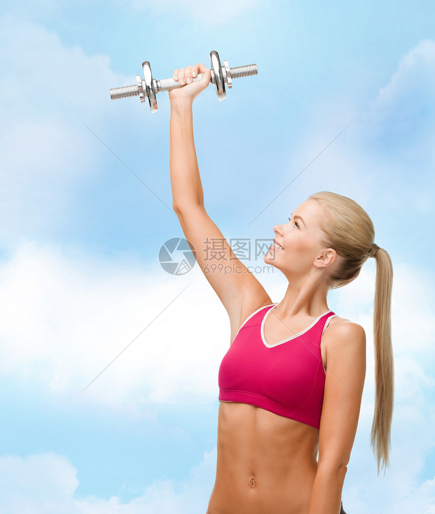 健身,保健节食的轻的运动妇女与沉重的钢哑铃图片