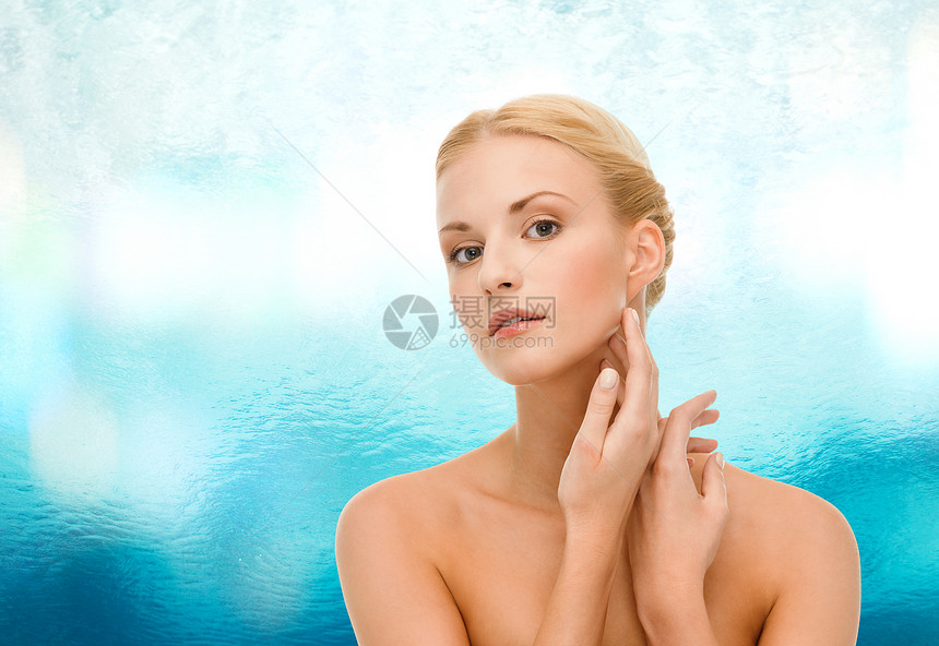美容水疗美丽的女人触摸她的脸皮肤图片