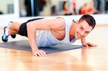 健身,运动,训练,健身房生活方式的微笑的男人健身房俯卧撑图片
