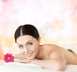 水疗,度假度假微笑的女人水疗沙龙躺按摩台上图片