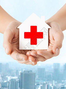 医疗保健医药慈善理念双手着带红十字标志的白纸屋图片