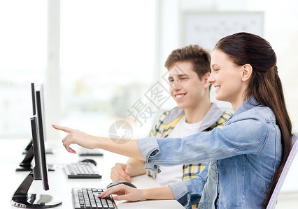 教育技术学校理念计算机两个微笑的学生,女孩指着屏幕图片
