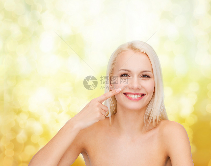 微笑的年轻女人指着她的鼻子图片