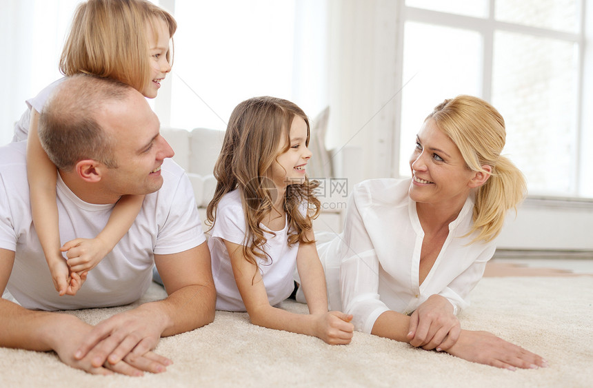 微笑的家庭两个小女孩躺家里的地板上图片