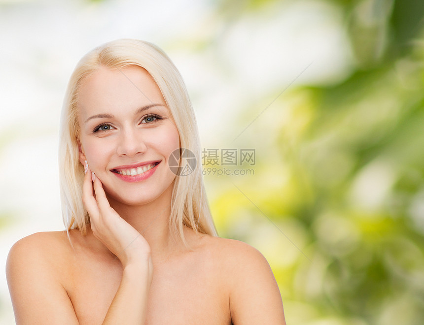 微笑的女人触摸她的脸皮肤图片