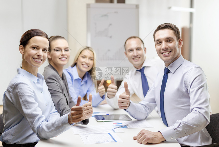 微笑的商业队与平板电脑论文大拇指办公室图片