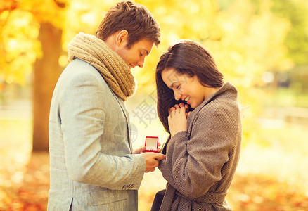 浪漫的男人秋天的公园向女人求婚图片