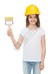 微笑的小女孩防护头盔与油漆刷图片