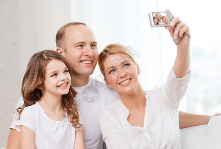 家庭,孩子,摄影家庭快乐的家庭与小女孩用数码相机自肖像图片