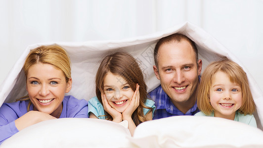 家庭,孩子家庭的幸福的家庭与两个孩子家里毯子下图片