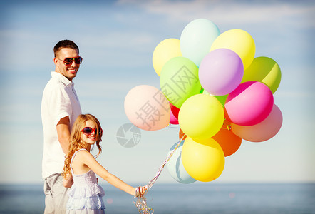 暑假,庆祝,孩子家庭的快乐的父亲女儿海边用五颜六色的气球图片