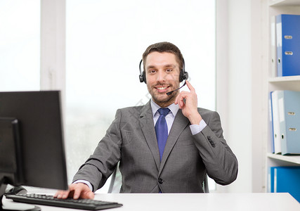 商业,通信,技术呼叫中心友好的男帮助热线运营商与耳机计算机呼叫中心图片