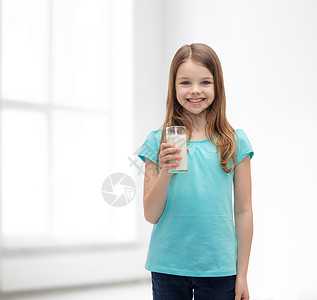 健康美丽的微笑的小女孩带着杯牛奶图片