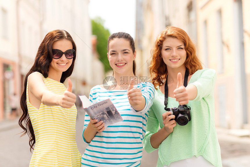 旅游,休闲,假日友谊的微笑的十几岁女孩与城市指南相机拇指户外图片