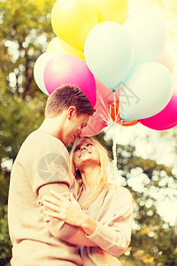 暑假,庆祝约会的微笑的夫妇与彩色气球公园图片