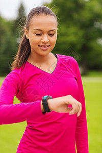 体育,健身,技术,医疗保健人的微笑的轻妇女与心率手表户外图片