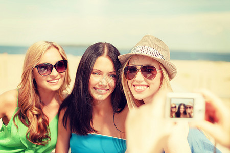暑假假期微笑的女孩海滩上的咖啡馆用数码相机拍照图片
