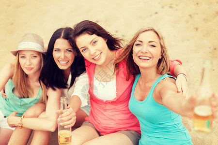 暑假假期微笑的女孩海滩上喝饮料图片