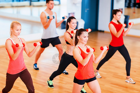健身,运动,训练,健身房生活方式的群微笑的人健身房里用哑铃锻炼图片