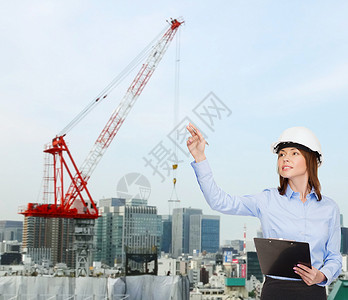 建筑,发展,建筑建筑微笑的女商人戴着白色头盔,剪贴板指向手指图片