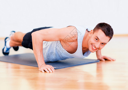 健身,运动,训练,健身房生活方式的微笑的男人健身房家里俯卧撑图片