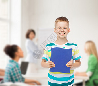 教育,童,队合作学校理念微笑的小学生男孩与蓝色的书超过群学生课堂上图片