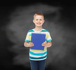 教育,童学校的微笑的小学生男孩与蓝色的书黑板背景图片