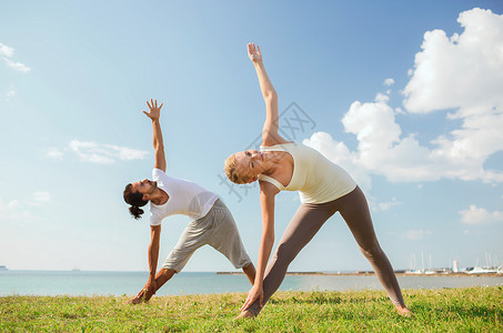 健身,运动,友谊生活方式的微笑的夫妇户外瑜伽练图片