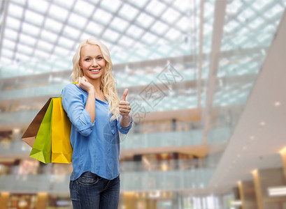 零售,手势销售微笑的女人与许多购物袋竖大拇指图片