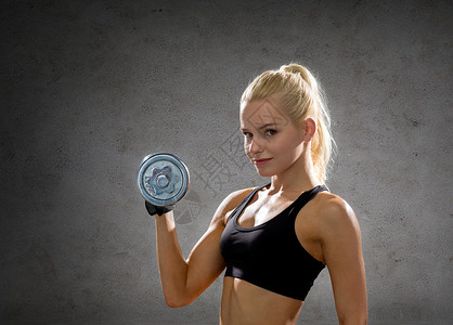 健身,运动,锻炼人的运动的女人与沉重的钢哑铃混凝土墙壁背景图片