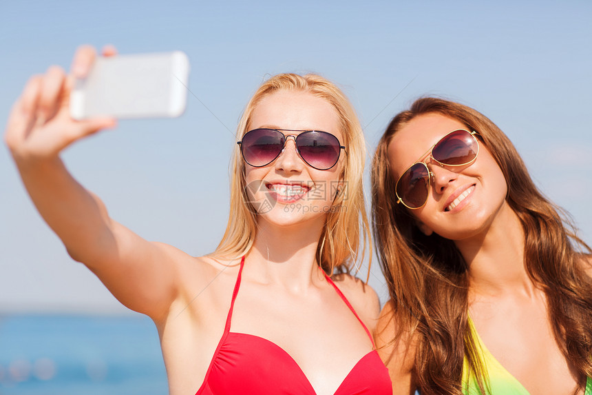 暑假,假期,旅行,技术人的两个微笑的轻女海滩上用智能手机蓝天背景下自拍图片