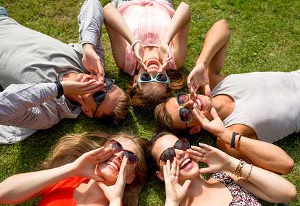 友谊,休闲,夏天人的群微笑的朋友躺草地上户外圆圈图片