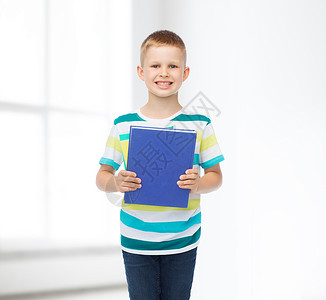 教育,童学校的微笑的小学生男孩,蓝色的书白色的房间背景图片