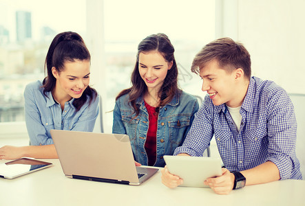 教育,技术,学校互联网的三个微笑的学生与笔记本电脑平板电脑学校图片