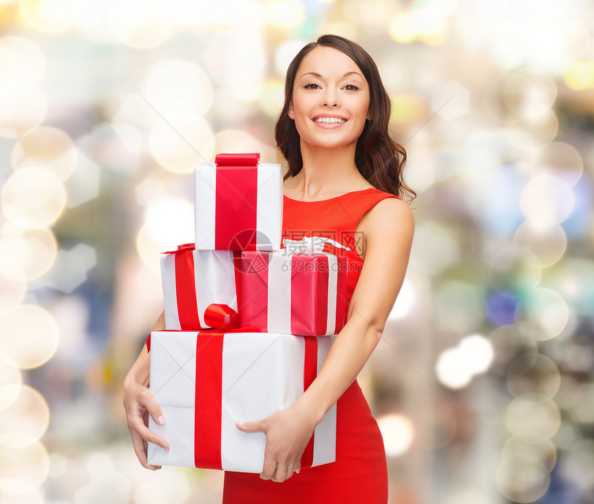 诞节,假日,情人节,庆祝人们的微笑的女人穿着红色连衣裙,灯光背景上礼品盒图片