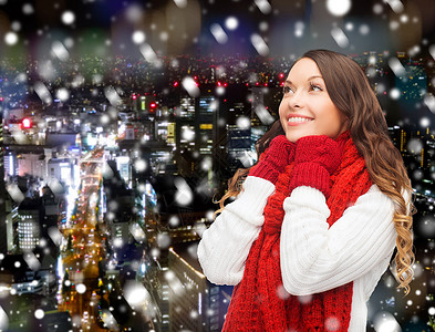 幸福,寒假,诞节人们的微笑的轻女人戴着红领巾手套雪夜的城市背景图片