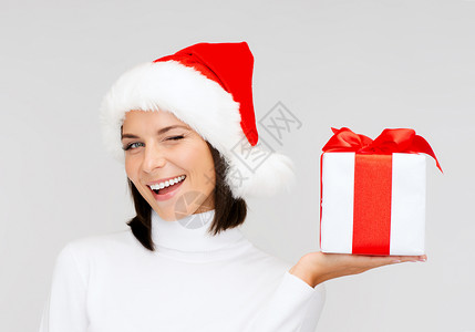 诞节,冬天,幸福的微笑的女人戴着诞老人的帽子礼品盒图片