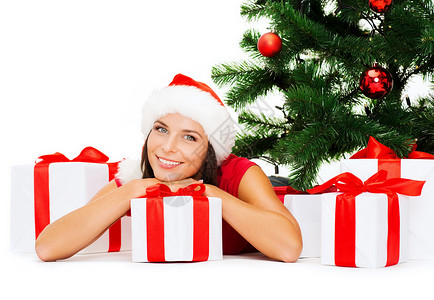诞节,冬天,幸福的微笑的女人戴着诞老人的帽子,许多礼品盒树图片