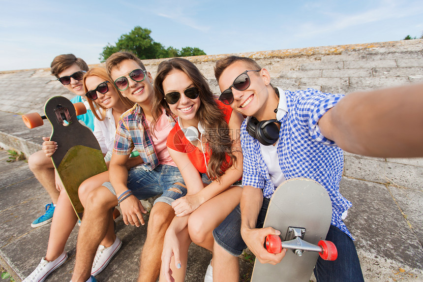 友谊,休闲,夏天,技术人的群微笑的朋友与滑板户外自拍图片