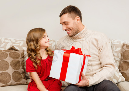 诞节,冬天,幸福人的微笑的父亲女儿抱着礼品盒,互相看着图片