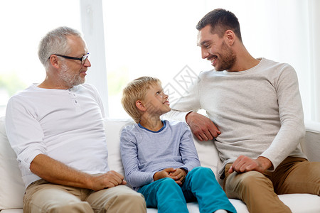 家庭幸福世代人的微笑的父亲儿子祖父坐家里的沙发上图片